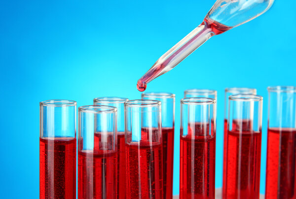 Test tubes with blood in laboratory on blue background