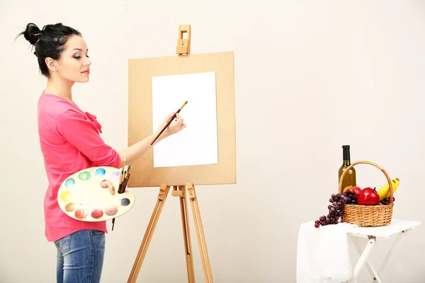 Belle jeune femme peintre au travail, sur fond de couleur — Photo