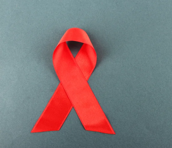 Nastro rosso HIV, AIDS su sfondo grigio — Foto Stock
