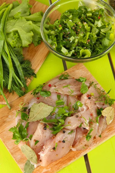 Hühnerfleisch im Glasteller, Kräuter und Gewürze auf Holztisch — Stockfoto