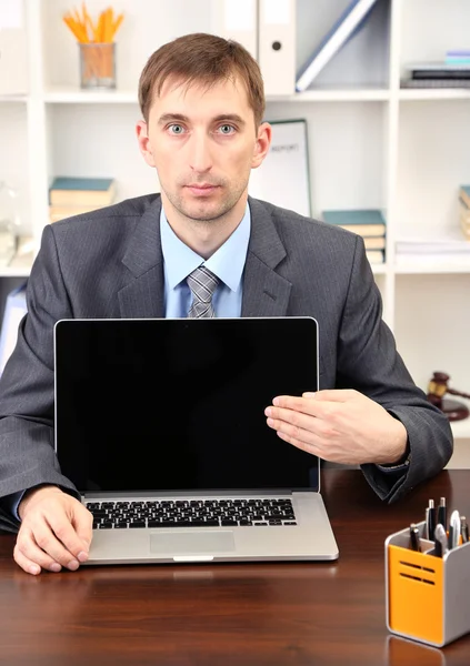 Giovane uomo d'affari con computer portatile di fronte sul suo posto di lavoro — Foto Stock