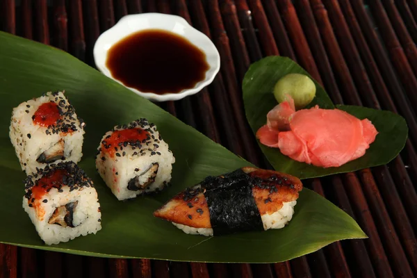 Tasty Maki sushi - Roll on green leaf on bamboo mat — Stock Photo, Image