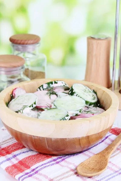 Витаминный овощной салат в деревянной чаше на деревянном столе на естественном фоне — стоковое фото