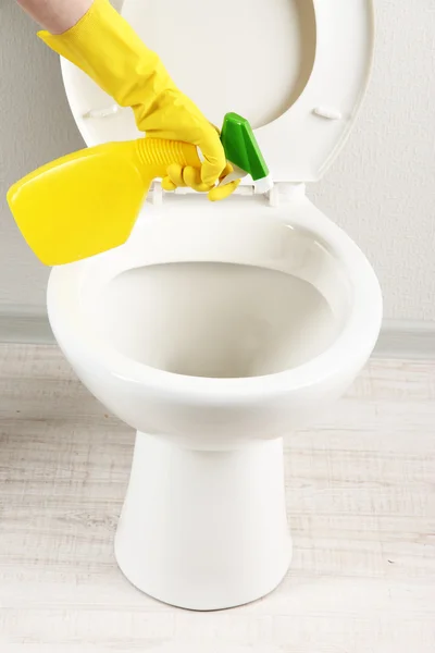 Frau Hand mit Sprühflasche reinigt Toilettenschüssel im Badezimmer — Stockfoto