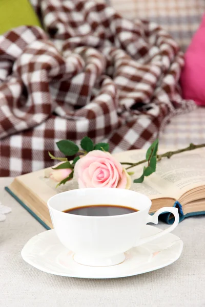 Composition with cup of drink, book and flowers on home interior background — Stock Photo, Image