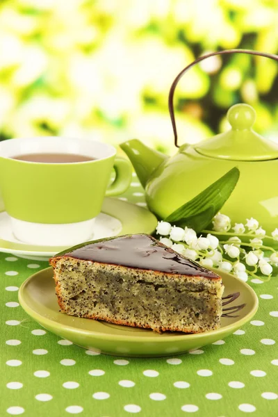 Delicious poppy seed cake with cup of tea on table on bright background — Stock Photo, Image