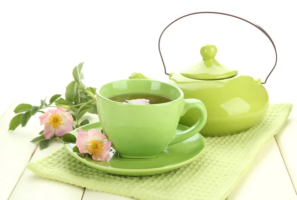 Tasse und Teekanne Kräutertee mit hippen Rosenblüten auf weißem Holztisch — Stockfoto