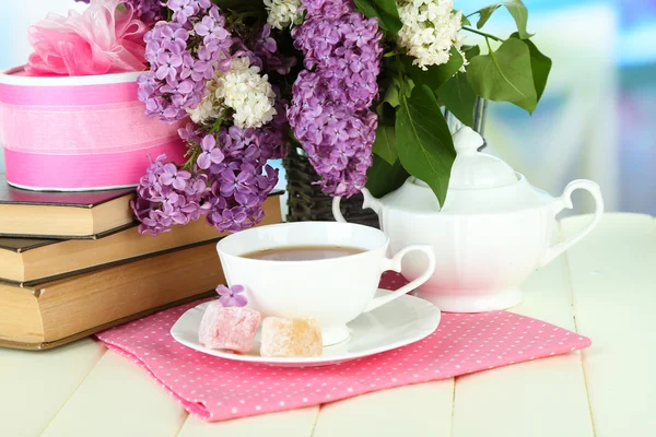 Composição com belas flores lilás, serviço de chá na mesa de madeira no fundo brilhante — Fotografia de Stock