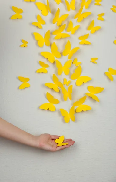 Papiergelbe Schmetterlinge fliegen an der Wand in verschiedene Richtungen — Stockfoto