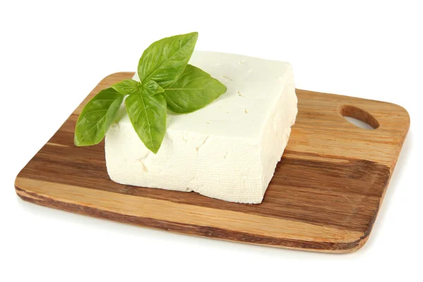 Queso de leche de oveja con albahaca en la tabla de cortar, aislado en blanco — Foto de Stock