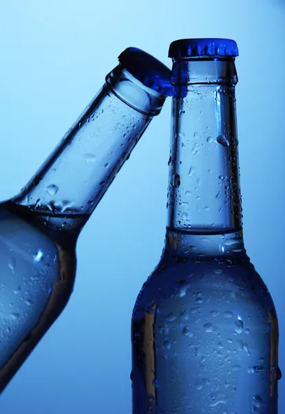Пляшки води на синьому фоні — стокове фото