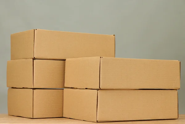 Cajas de paquetes sobre mesa de madera, sobre fondo gris — Foto de Stock