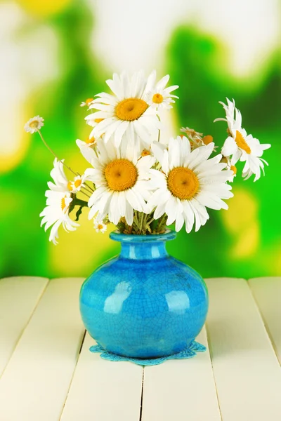 Beautiful bouquet chamomiles in vase on wooden table on natural background — Stock Photo, Image