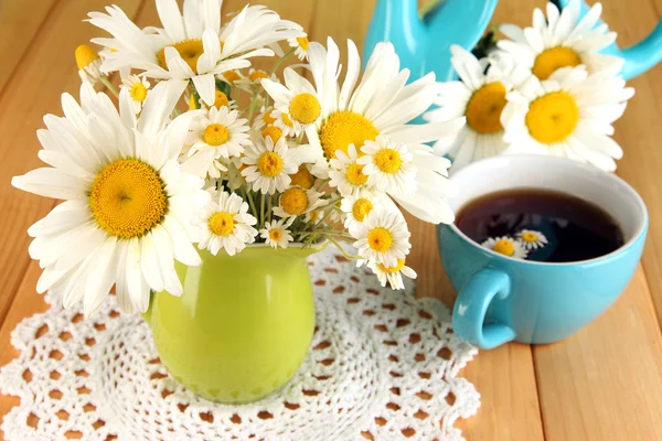 Beautiful bouquet chamomiles in pitcher on wooden table close-up — Stock Photo, Image