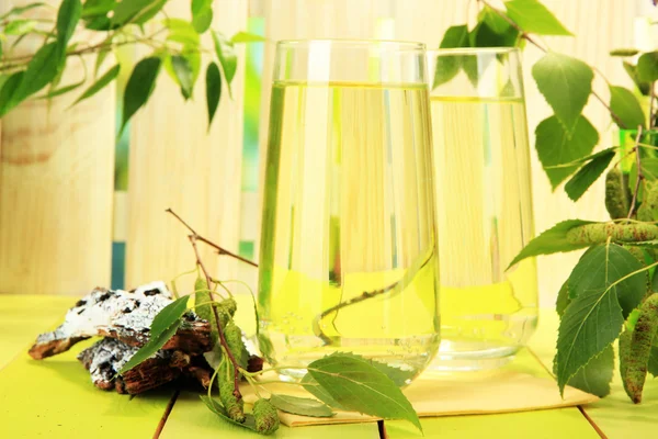 Glasses of birch sap on green wooden table — Stock Image Glasses of birch sap on green wooden table Stock Picture