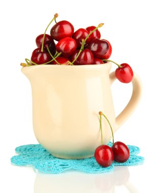 Olgun kırmızı kiraz meyveleri üzerinde beyaz izole sürahi