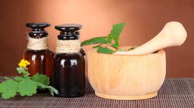 İlaç şişe masanın üzerinde kahverengi zemin üzerinde ile çiçeklenme kırlangıçotu