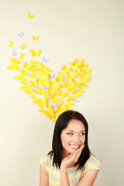 Girl near paper butterflies fly on wall — Stock Photo, Image