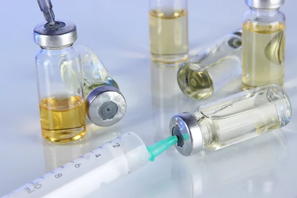 Medical bottles and syringes on light gray background — Stock Photo, Image