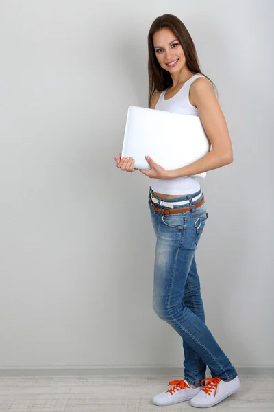 Bella giovane donna con computer portatile in camera — Foto Stock