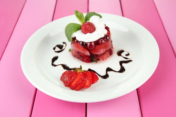 Смачний желе-десерт зі свіжими ягодами, на кольоровому дерев'яному фоні — стокове фото