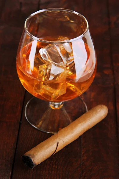 Bicchiere di brandy con ghiaccio su sfondo di legno — Foto Stock