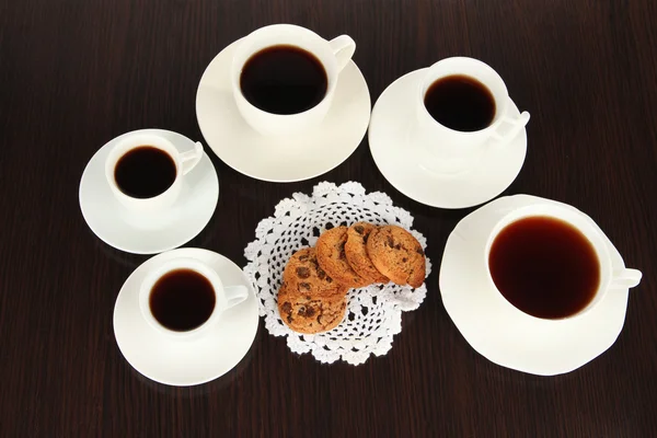 Xícaras de café e biscoitos em guardanapo no fundo escuro — Fotografia de Stock