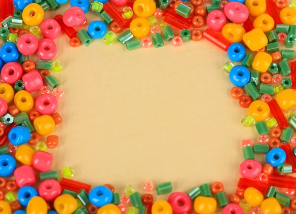 Diferentes grânulos coloridos no fundo bege — Fotografia de Stock
