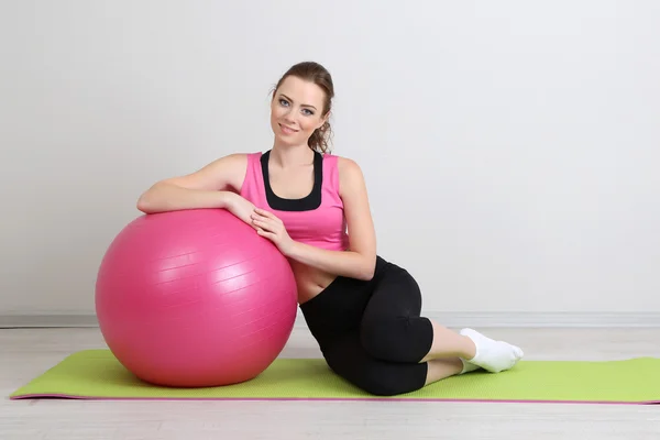 Porträtt av vacker ung kvinna övningar med gym boll — Stockfoto