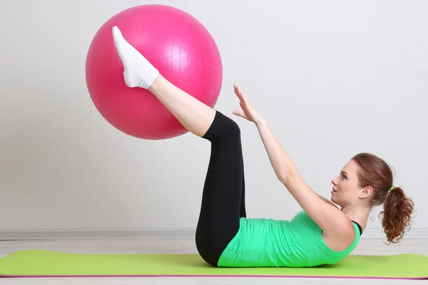 Porträtt av vacker ung kvinna övningar med gym boll — Stockfoto