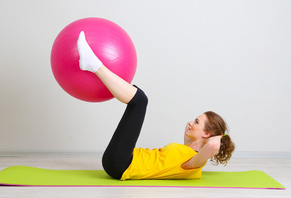 Портрет красивой молодой женщины упражнения с мячом спортзал
