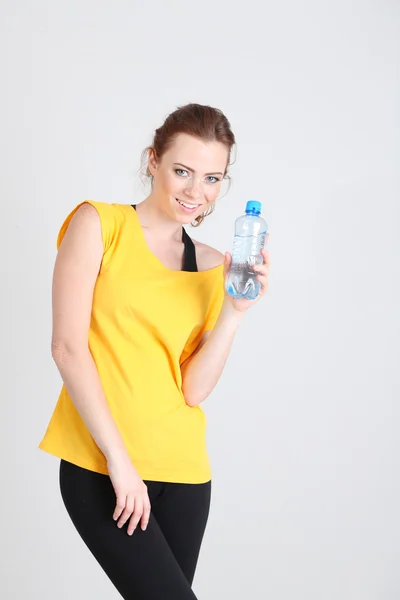 Beautiful young woman with bottle of water — Stock Photo, Image