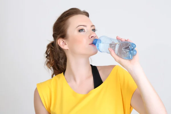 Schöne junge Frau mit Flasche Wasser — Stockfoto