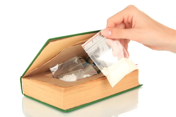 Narcotiques main tenant près de la cachette de livre isolé sur blanc — Photo