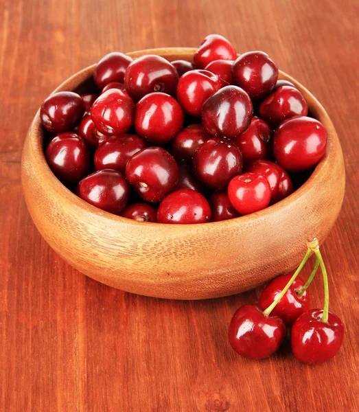 Cherry berries in bowl on wooden table close-up — Stock Photo, Image