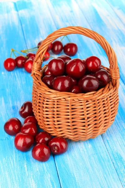 Kirschbeeren im Weidenkorb auf Holztisch in Großaufnahme — Stockfoto