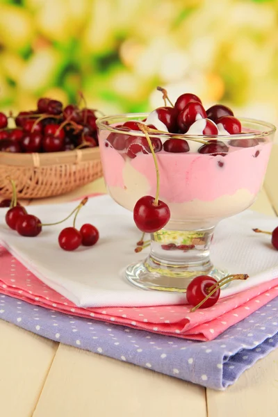 Delicious cherry dessert in glass vase on wooden table on natural background — Stock Photo, Image