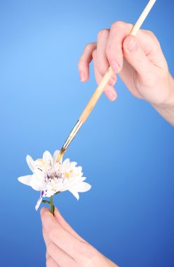 Beyaz holding eller çiçek ve renkli arka plan üzerinde renkli boya