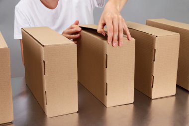 gri arka plan üzerinde Konveyör bant kutuları ile çalışan işçi
