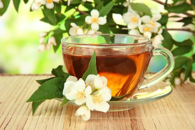 Yasemin, üzerinde parlak arka plan bambu hasır ile çay