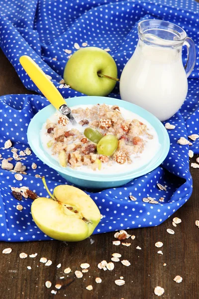 Användbara havregryn i skål med frukt på träbord närbild — Stockfoto