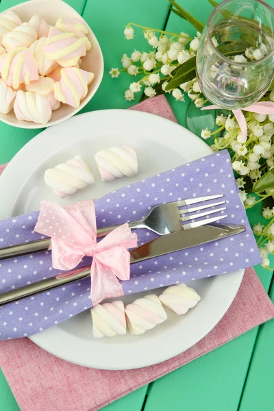 De instelling van de tabel in violette en roze tonen op een houten achtergrond kleur — Stockfoto