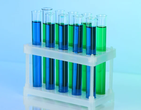 Tubos de ensaio idênticos sobre fundo azul — Fotografia de Stock