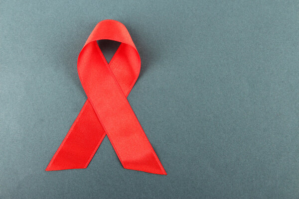 Красная лента ВИЧ, СПИД на сером фоне
