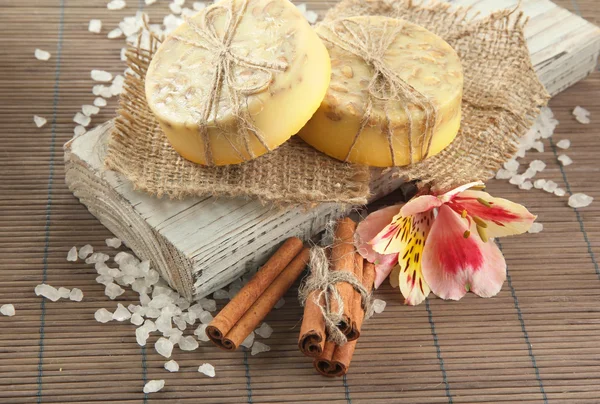 Мыло ручной работы и морская соль на сером бамбуковом коврике — стоковое фото