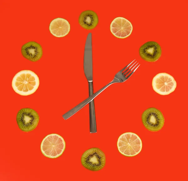 Horloge en tranches de kiwi, citron vert et citron, sur fond de couleur — Photo