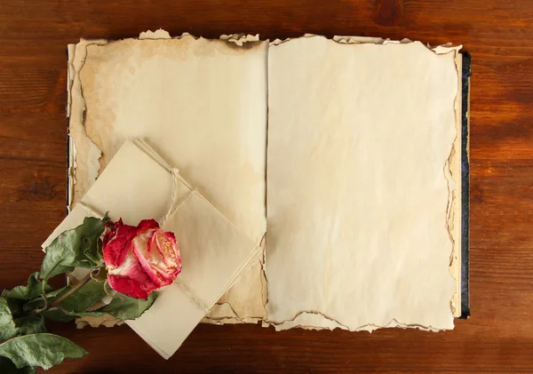 Ouvre vieux livre, lettres et rose sur fond en bois — Photo