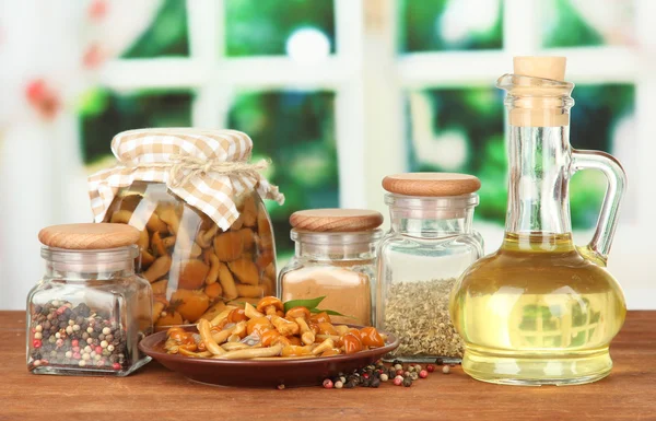 Composition of delicious marinated mushrooms, oil and spices on wooden table on bright background — Stock Photo, Image