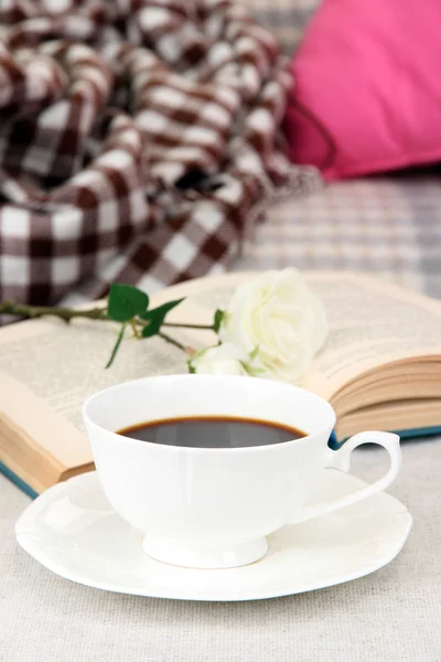 Komposition mit einer Tasse Getränk, einem Buch und Blumen auf dem heimischen Innenhintergrund — Stockfoto