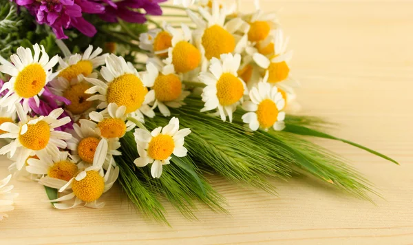 Wild flowers and green spikelets, on wooden background — Stock Photo, Image